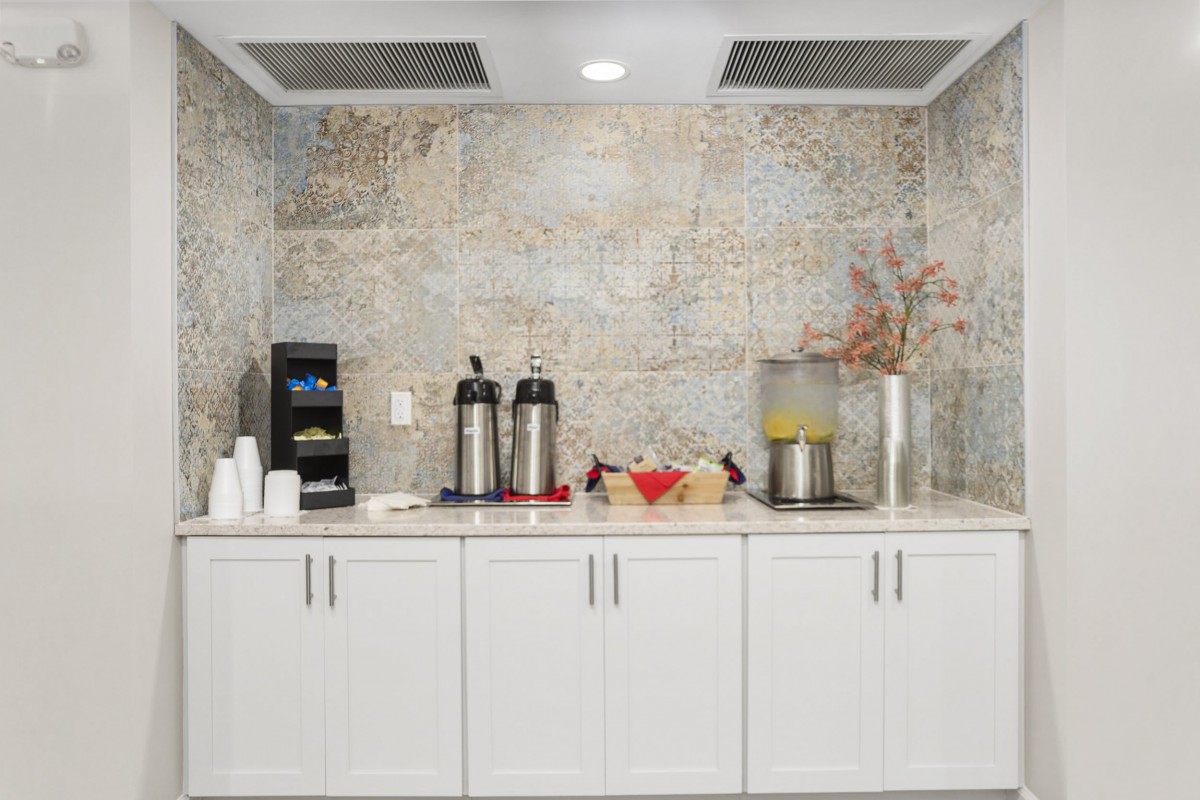 A well-organized beverage station with coffee and juice dispensers, cups, and decorative elements.