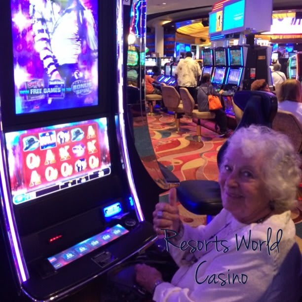 A person enjoying time at a casino, playing on a slot machine.