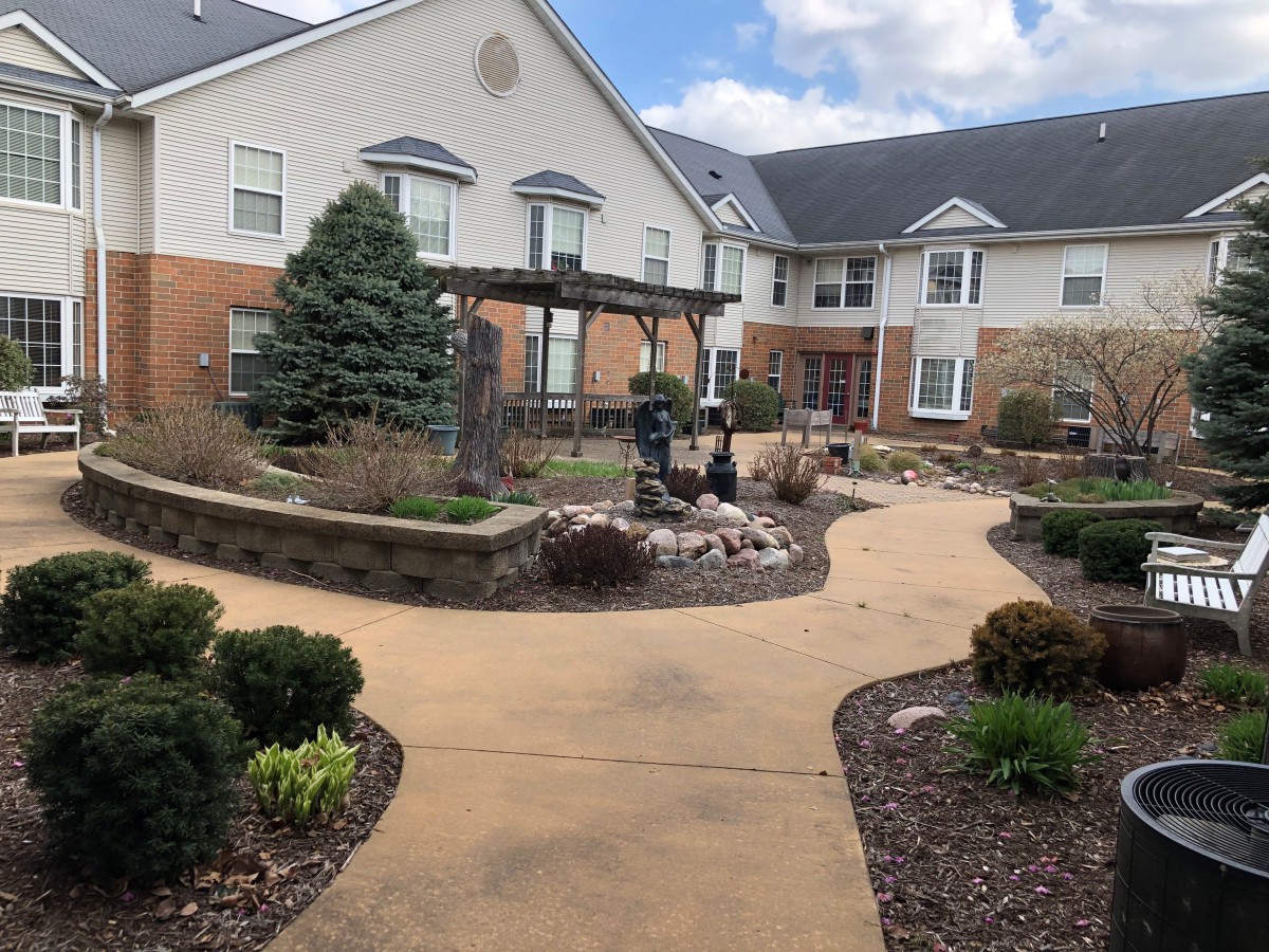 A well-maintained garden and pathway leading to a large residential building.