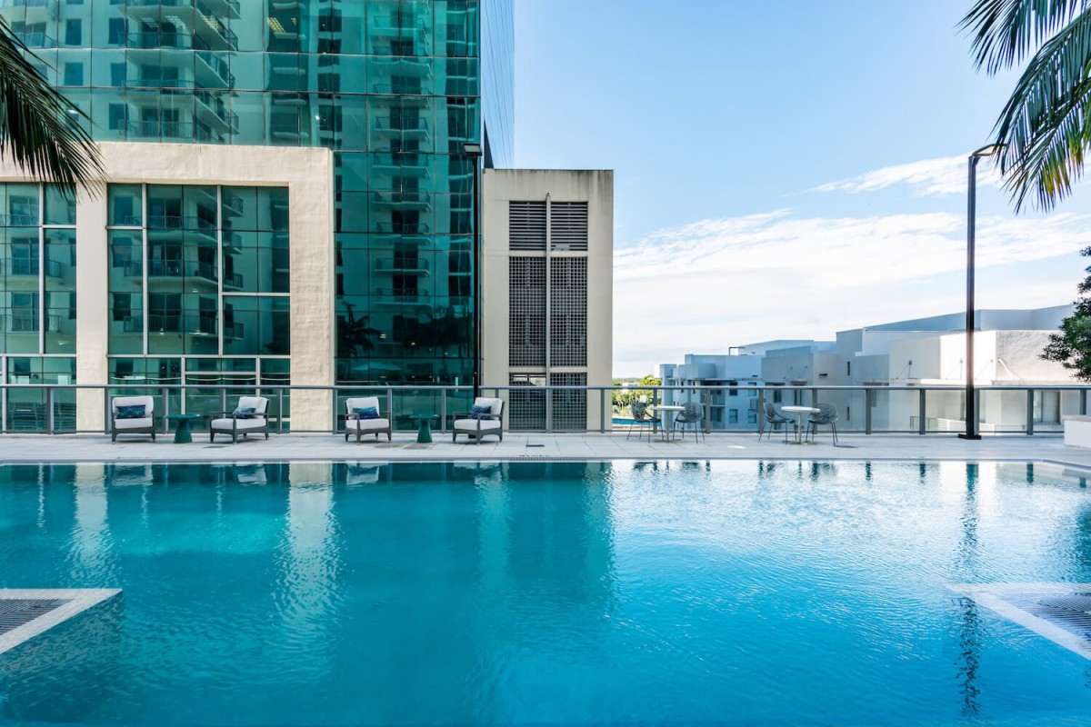 A modern high-rise building with a serene outdoor swimming pool.