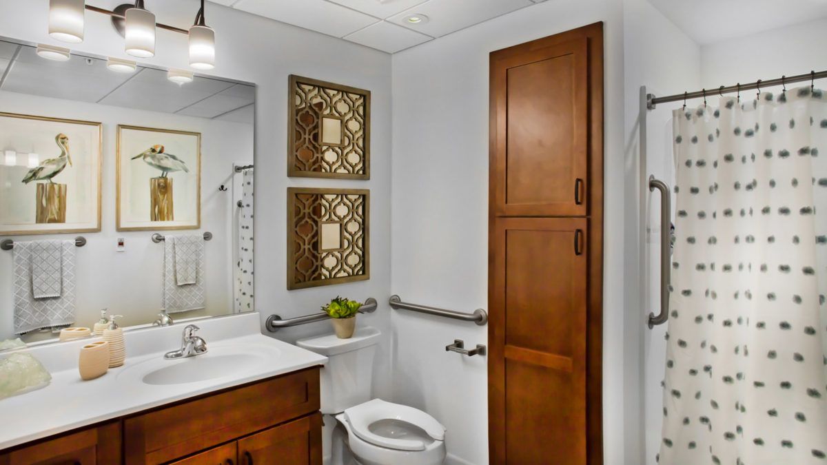 A well-organized bathroom with wooden cabinets and decorative wall elements.