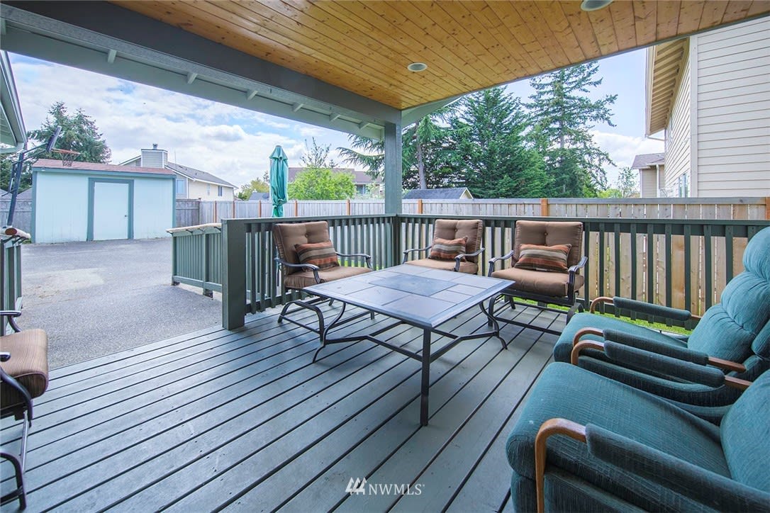 A cozy patio with comfortable seating and a table, perfect for outdoor relaxation.