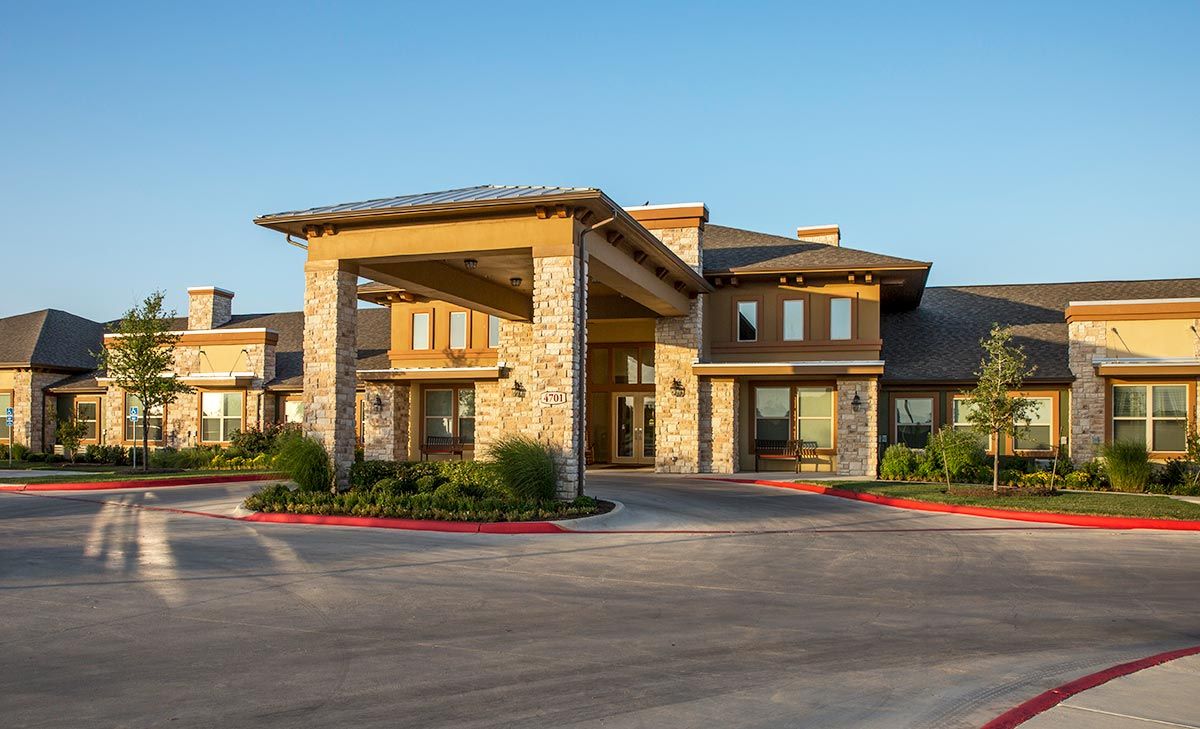 A modern commercial building with a grand entrance under a clear blue sky.