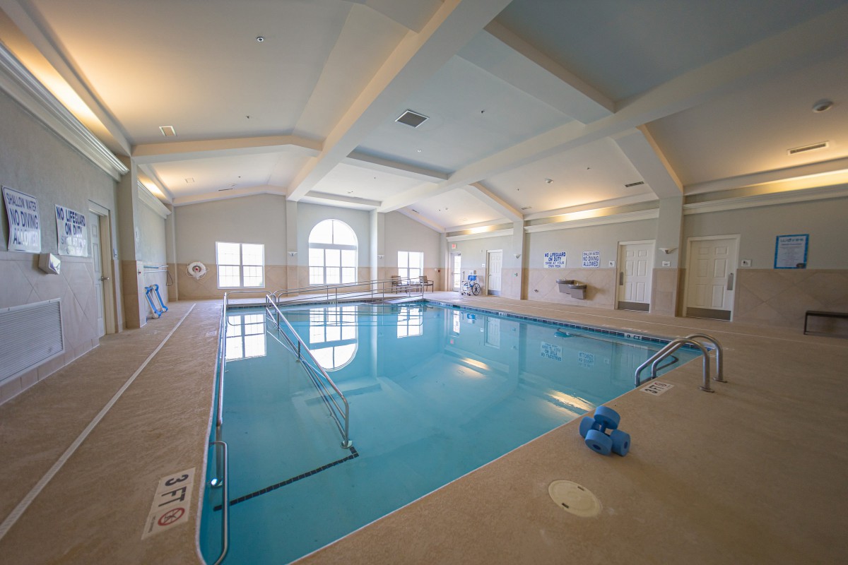 A spacious indoor swimming pool area with large windows and bright lighting.