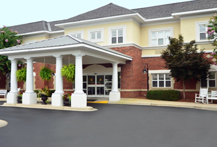 A welcoming entrance to a brick building with white columns.