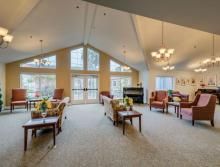 A spacious and well-lit living room with comfortable seating and large windows.