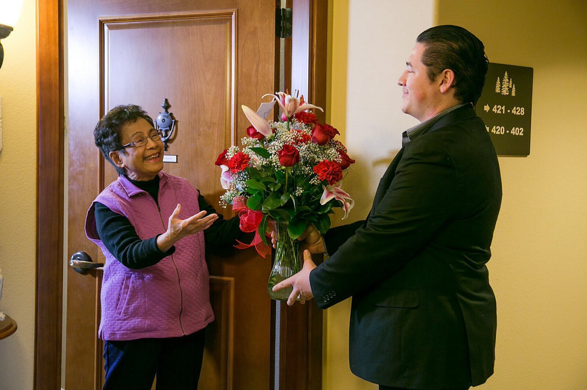 A person receives a bouquet of flowers at their doorstep.