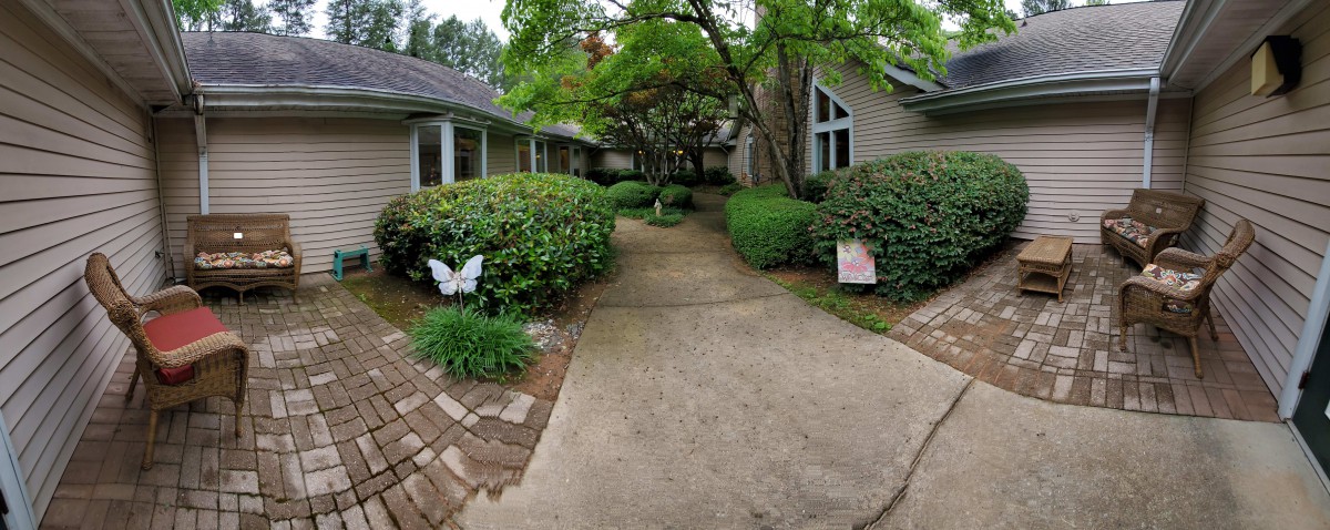 A serene walkway surrounded by lush greenery and decorative elements.