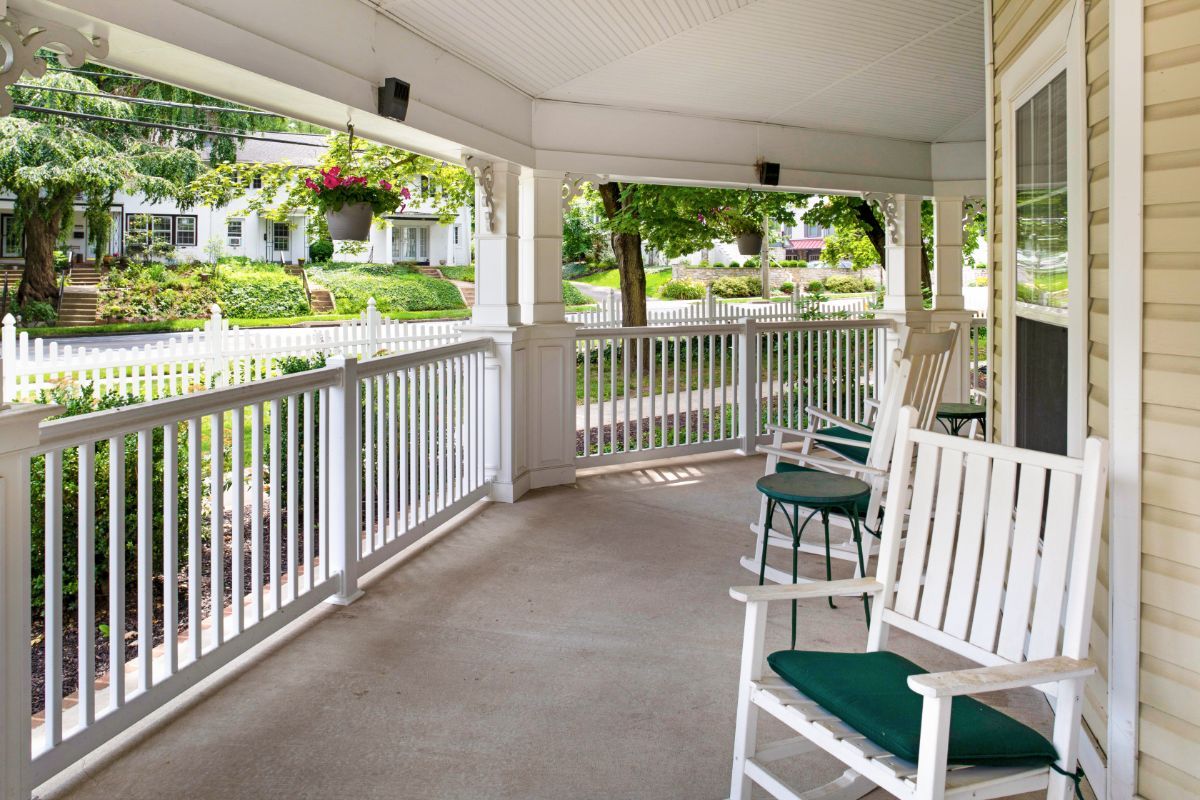 A serene porch with rocking chairs and a garden view.