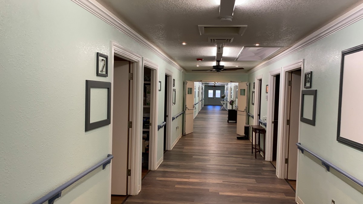 A well-lit interior hallway featuring multiple doorways and wood flooring.