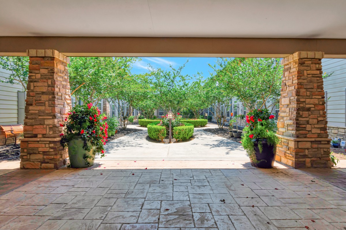 A beautifully landscaped garden pathway lined with vibrant potted plants.