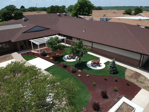 Aerial view of a beautifully landscaped outdoor space featuring seating areas, greenery, and pathways.