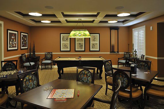 A cozy billiard room with a pool table and seating area.