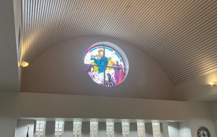 A colorful stained glass window depicting various figures inside a building.