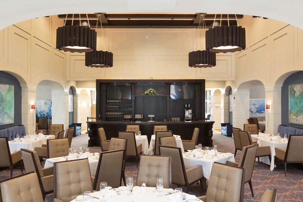An elegantly designed restaurant interior with neatly arranged dining tables and sophisticated lighting fixtures.