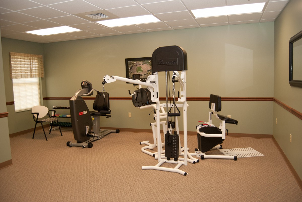 A gym room featuring various exercise equipment and workout machines.