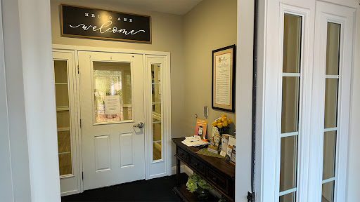 A warm and inviting entrance to an office space, featuring welcoming signage and a decorative table.