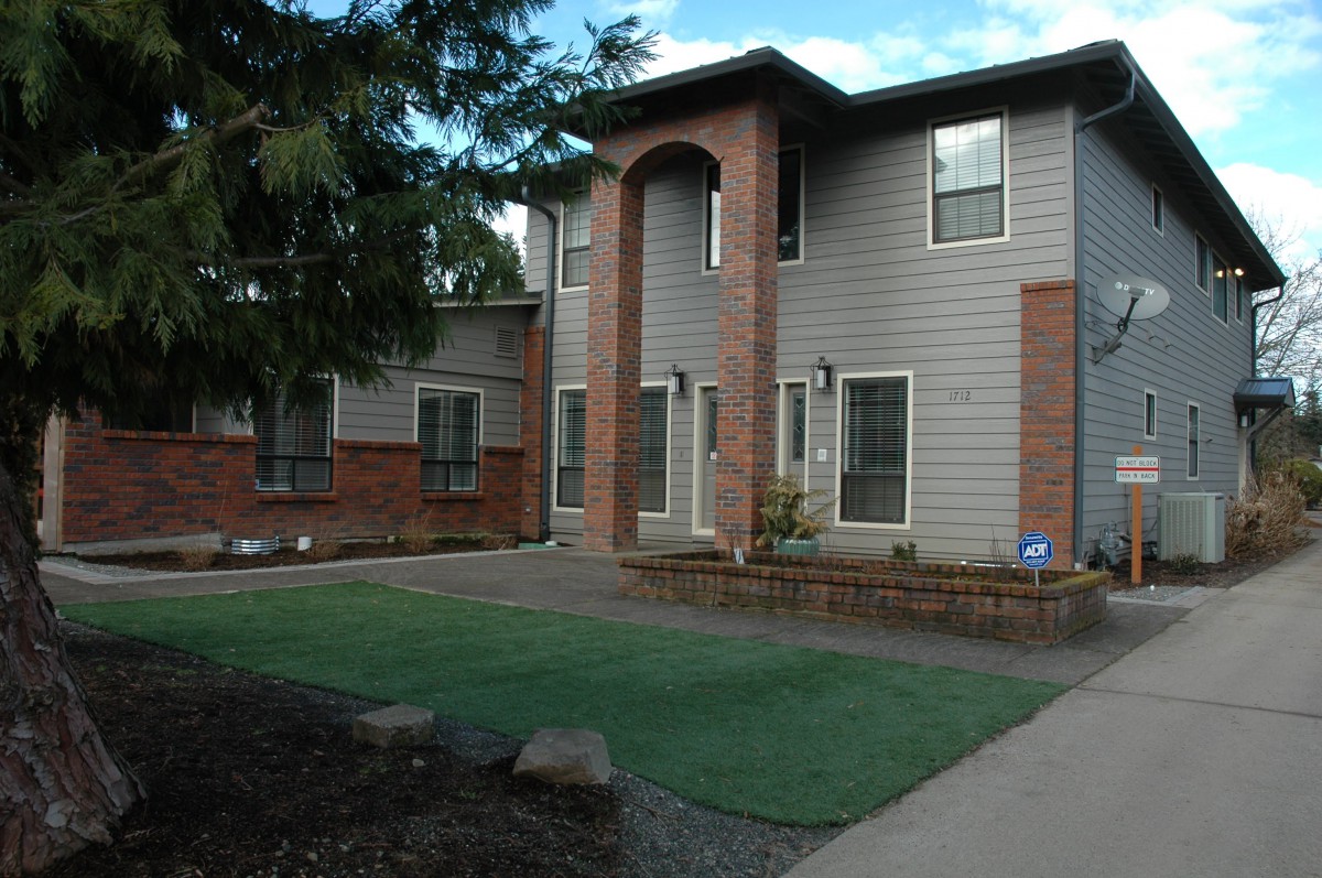 A suburban house with a brick facade and well-maintained lawn.