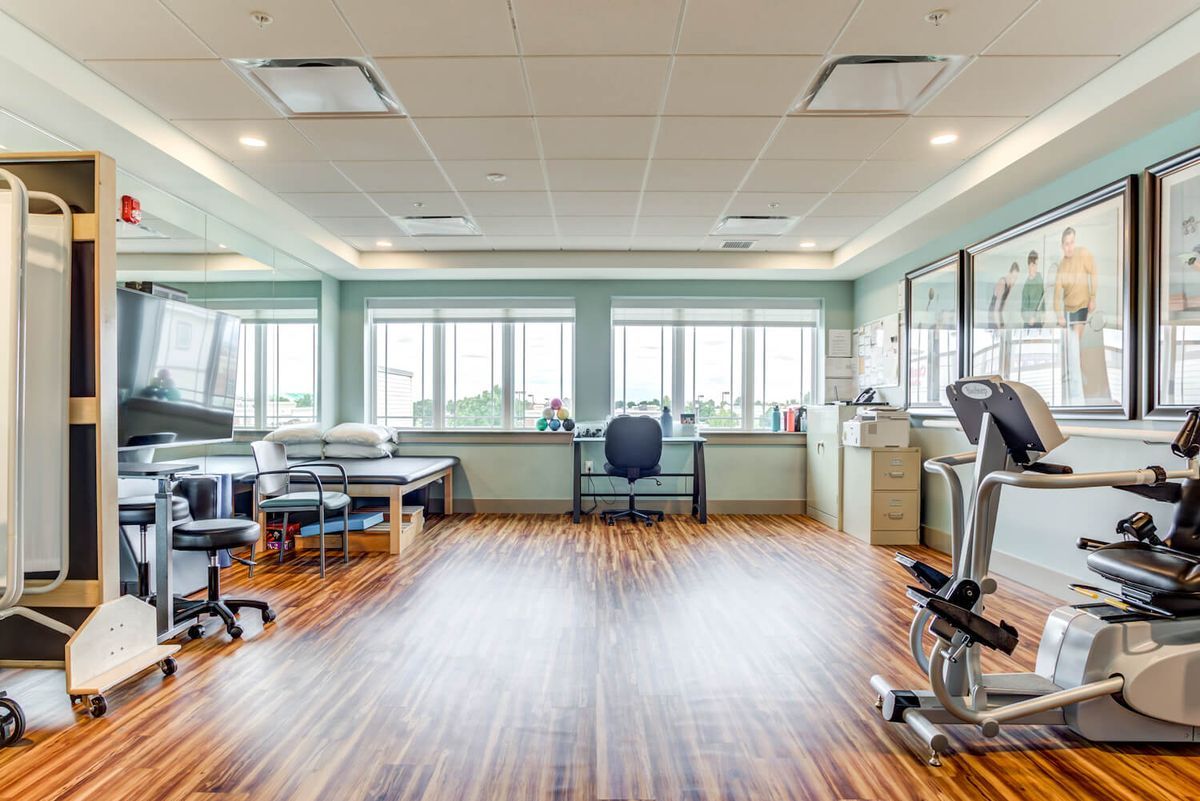 A bright and spacious physical therapy clinic equipped with exercise equipment and treatment areas.