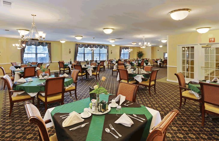 A spacious dining room with elegantly set tables and chairs.