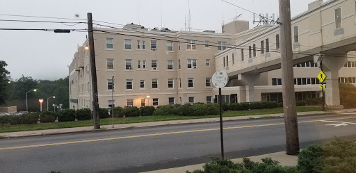 An exterior view of a hospital building on a cloudy day.