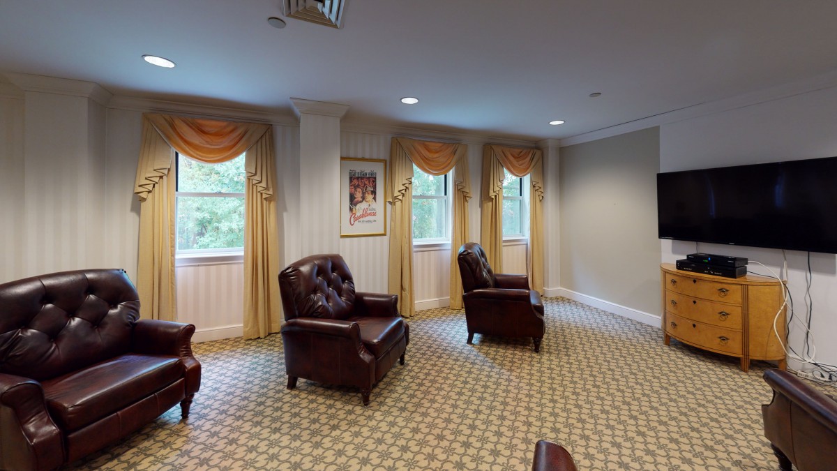 A cozy waiting room with armchairs and windows adorned with curtains.