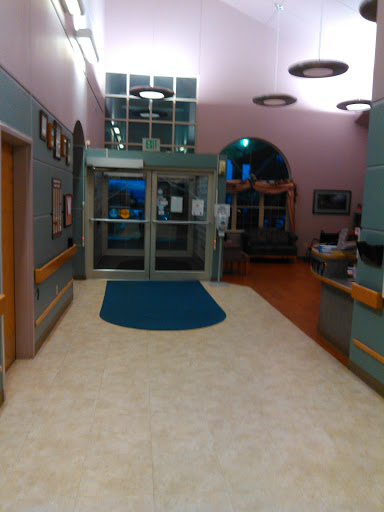 A view of the entrance lobby in a hospital, featuring a welcoming reception area and spacious waiting space.