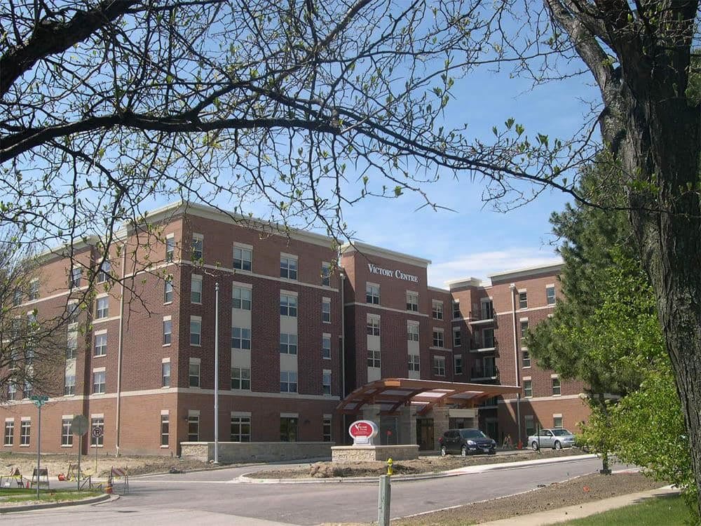 A brick building surrounded by trees on a clear day.