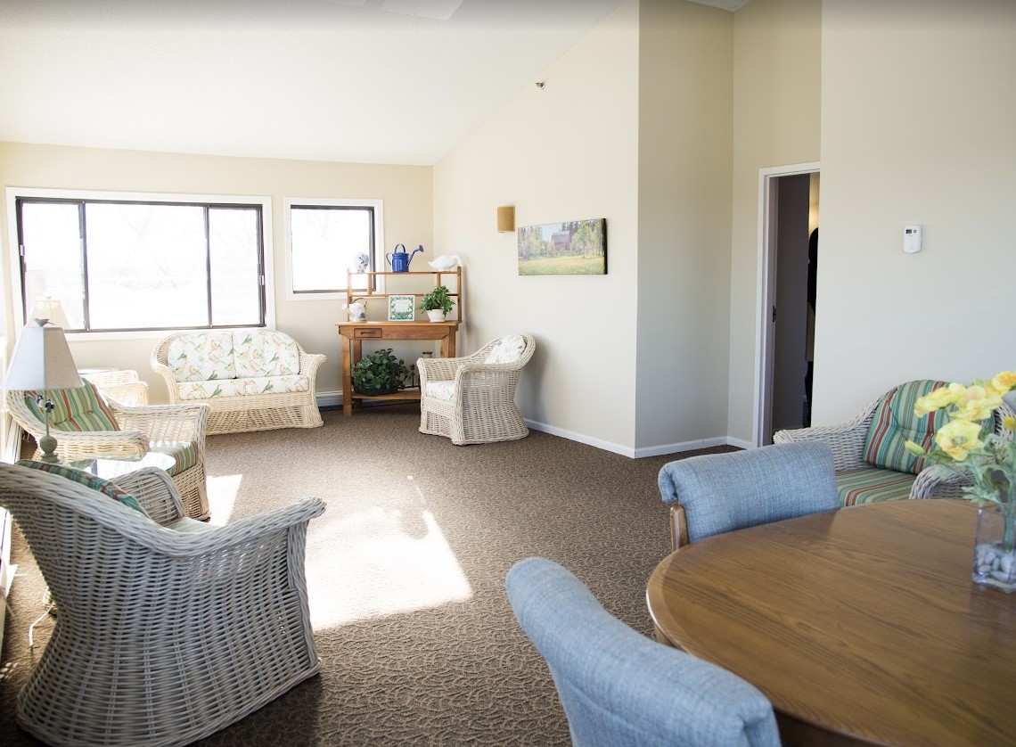 A bright and spacious living room with various seating options and natural light streaming through the windows.