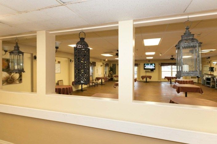 A spacious room view through wide windows featuring hanging decor and indoor lighting.
