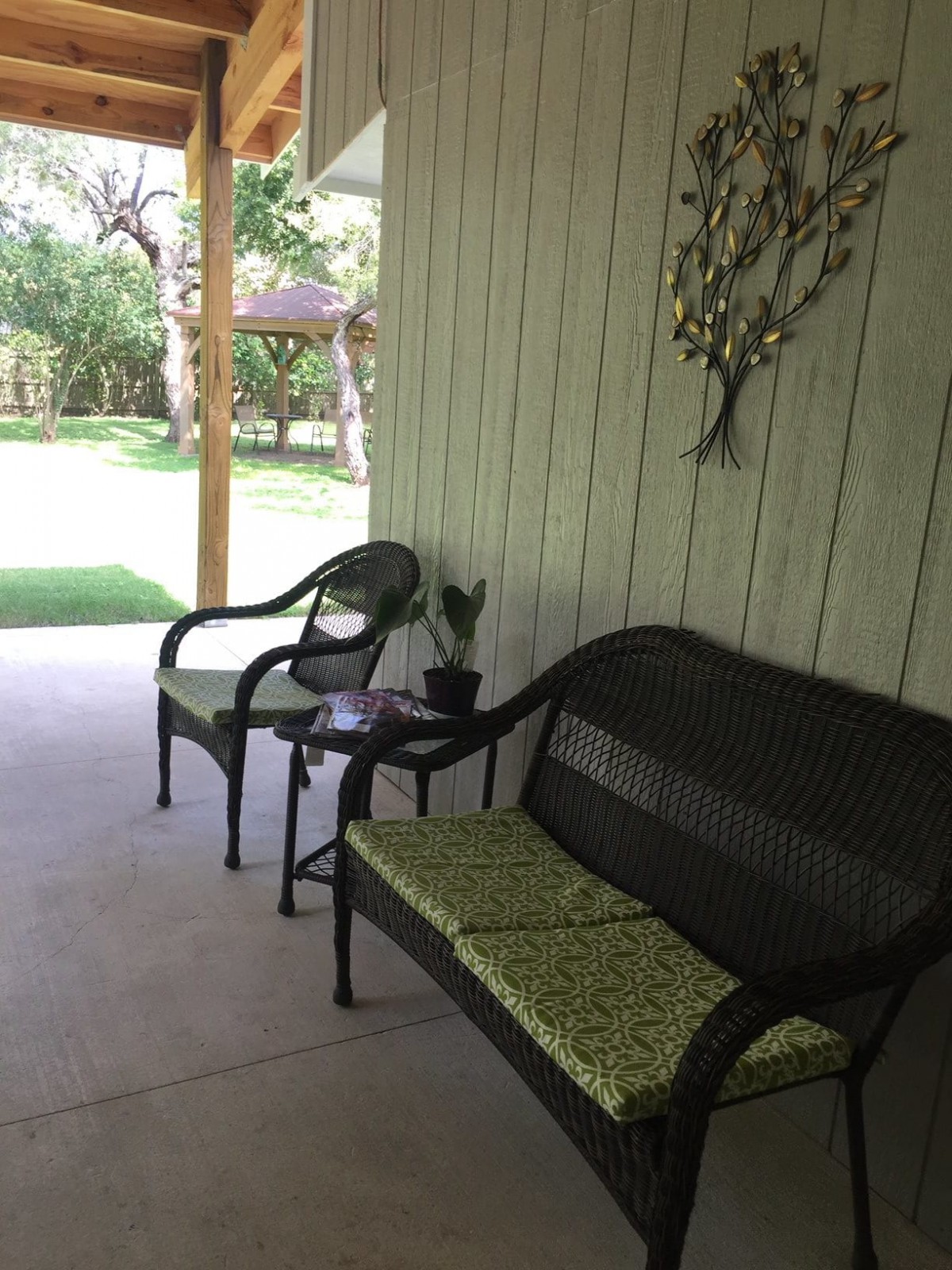 A cozy patio area with seating overlooking a green backyard.