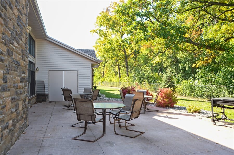 A sunny patio with outdoor furniture and a view of the garden.