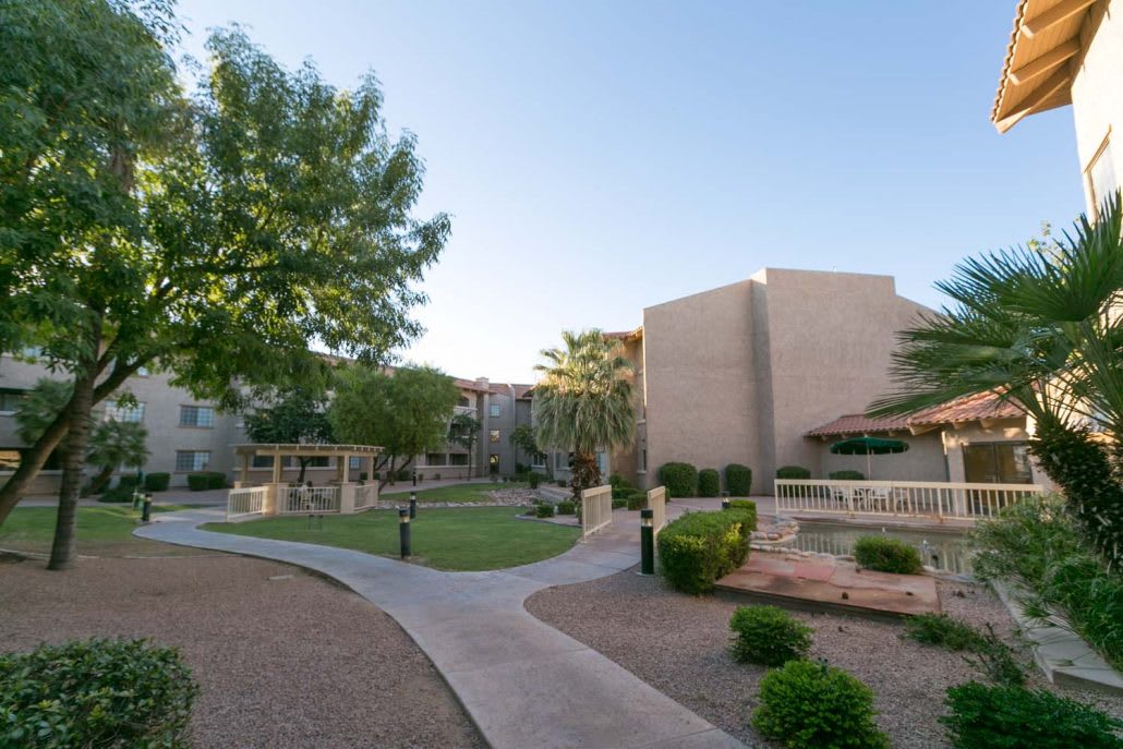 A scenic view of an apartment complex with manicured landscaping and pathways.