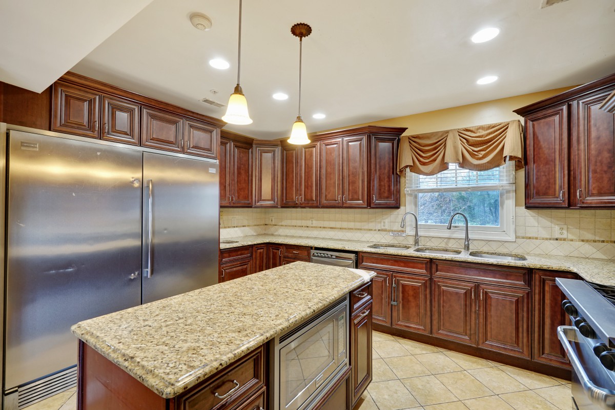 Modern kitchen with granite countertops and wood cabinets.