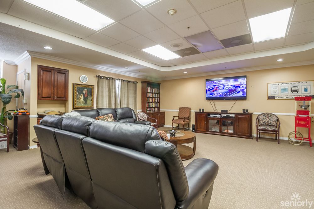 A comfortable lounge area with leather sofas and a large TV in an office setting.