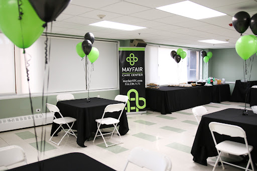 A well-decorated event space featuring black and green balloons, tables, and a promotional banner.