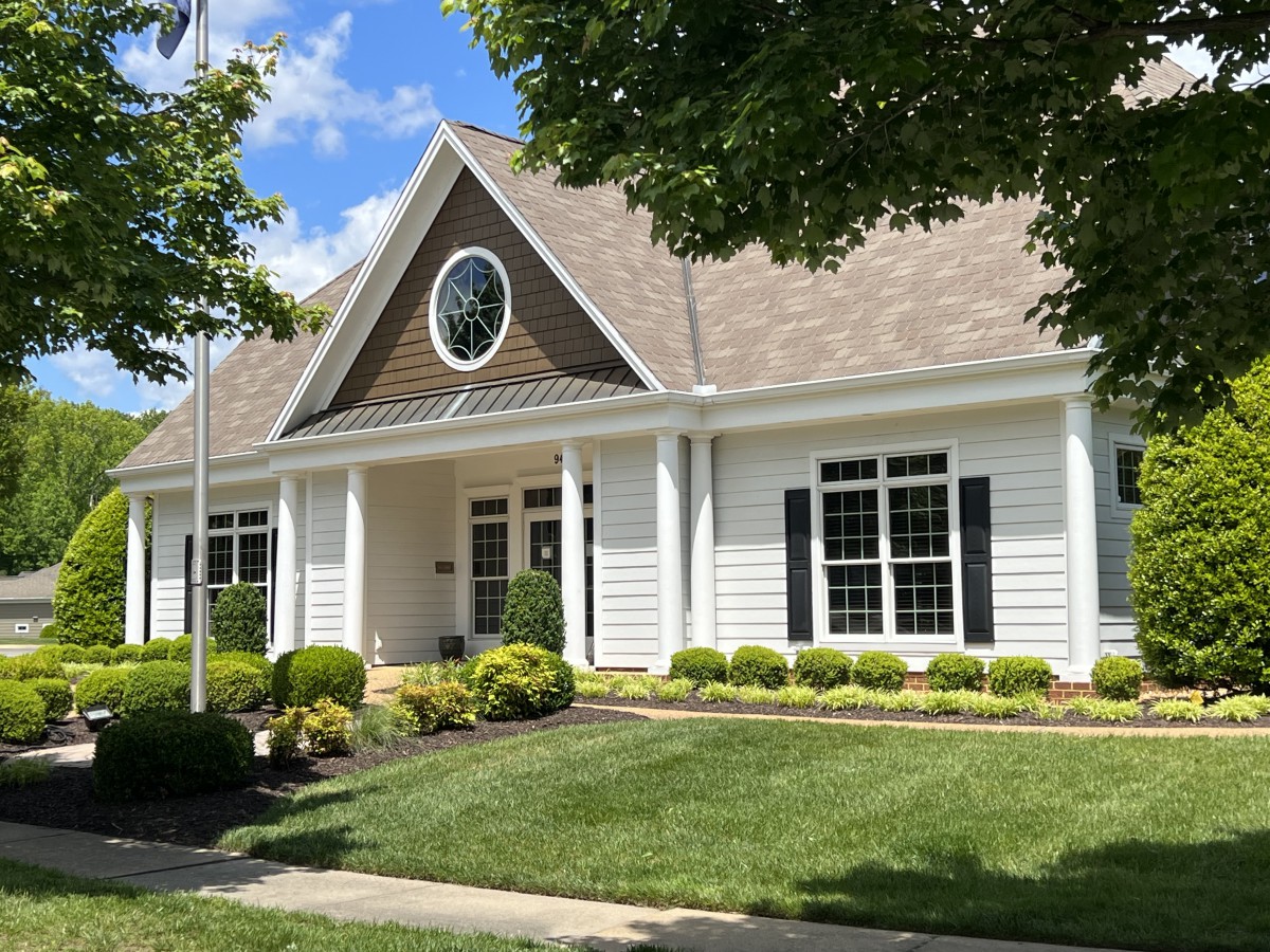 A charming suburban house with well-maintained landscaping and a circular window.