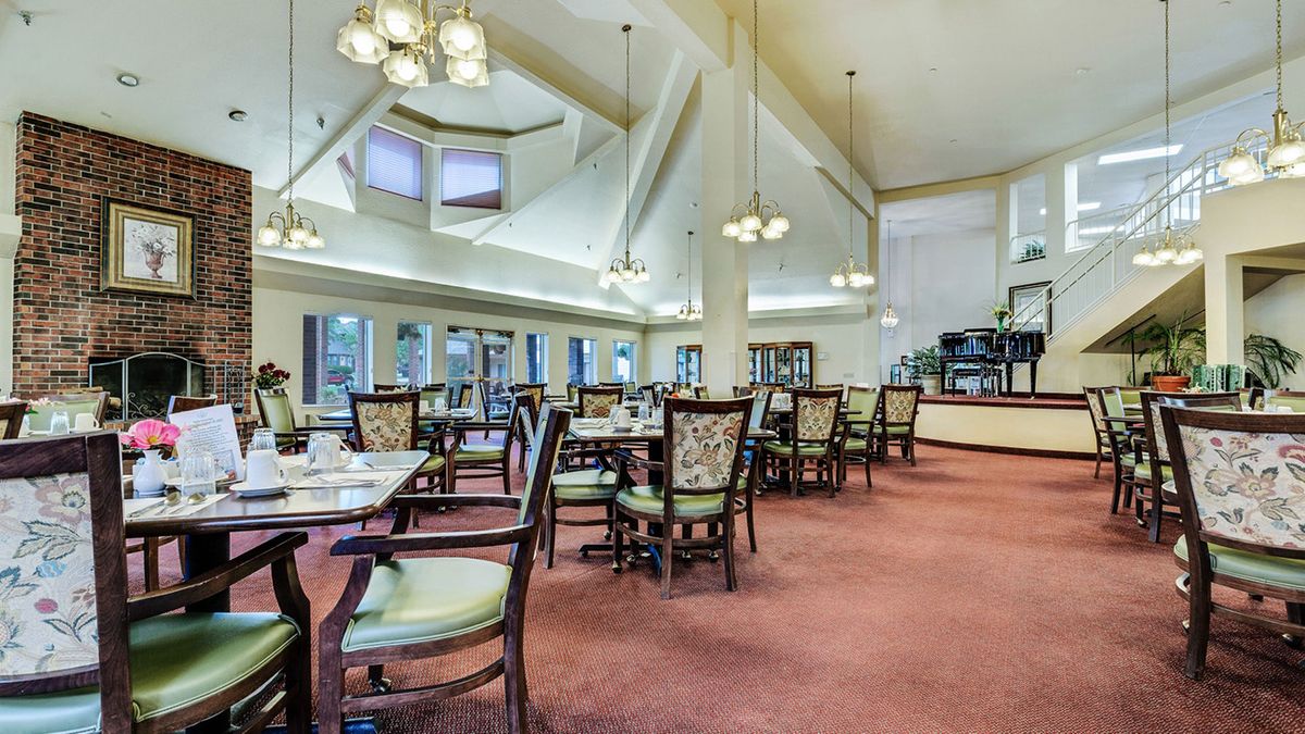 Spacious dining area with elegant chandeliers and well-arranged tables.