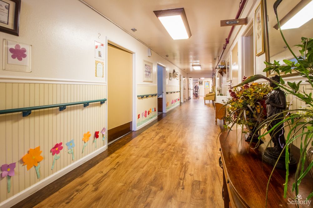 A brightly decorated hospital hallway with wooden flooring, likely part of a children's ward.