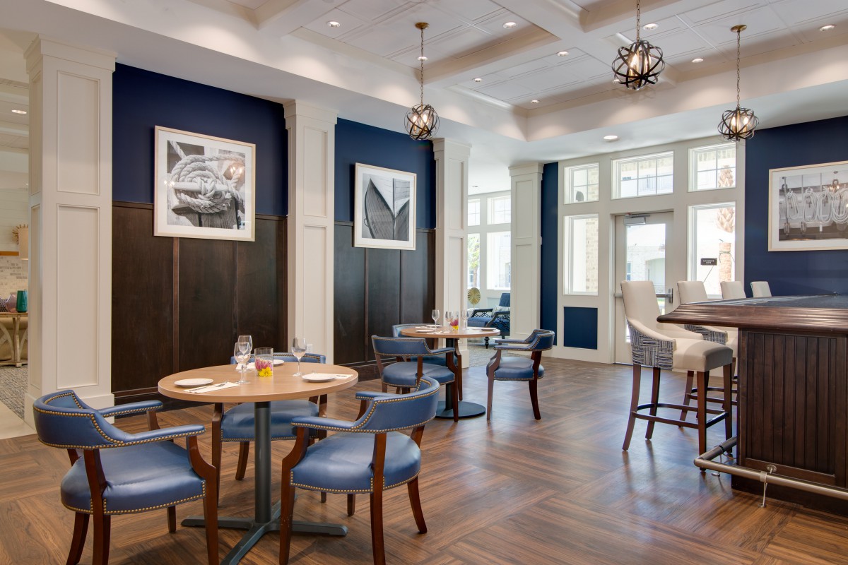 A modern restaurant interior with stylish tables and chairs, featuring elegant lighting and decor.