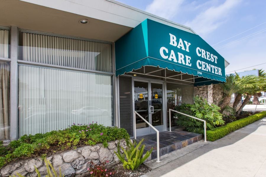 Entrance to Bay Crest Care Center with a green awning.