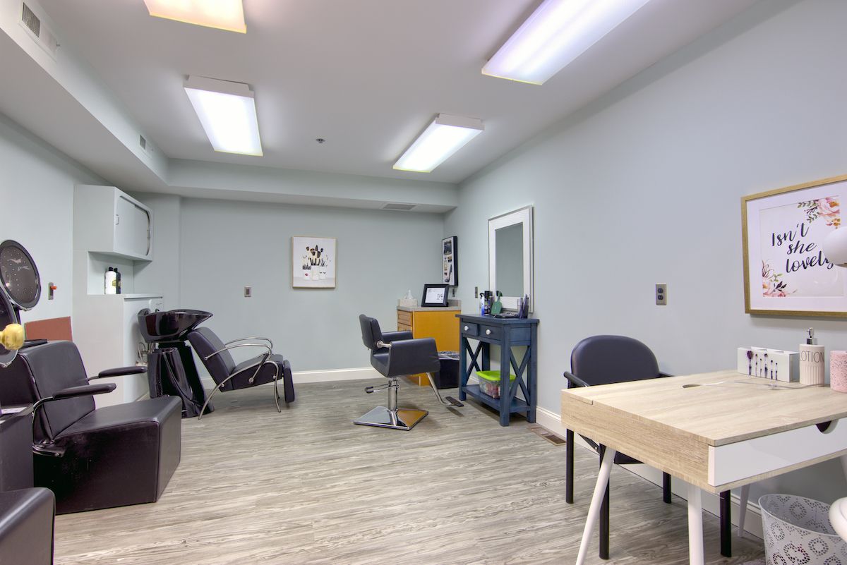 A modern salon interior with chairs, a sink, and mirrors.