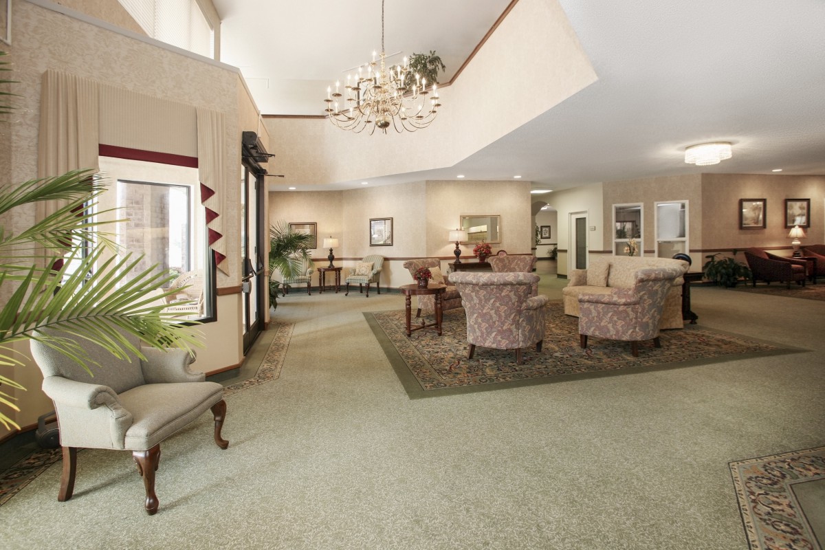 A spacious lobby with elegant furniture and a chandelier.