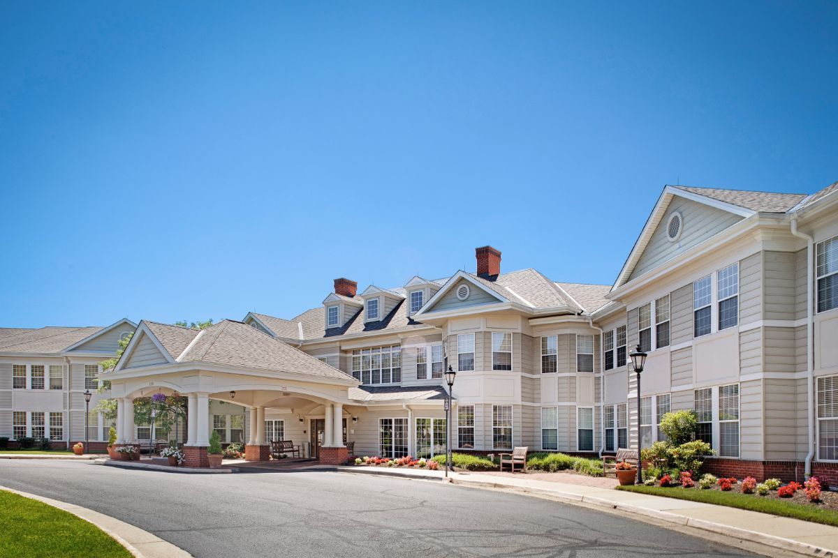 A large residential-style building with a covered entrance and expansive driveway.