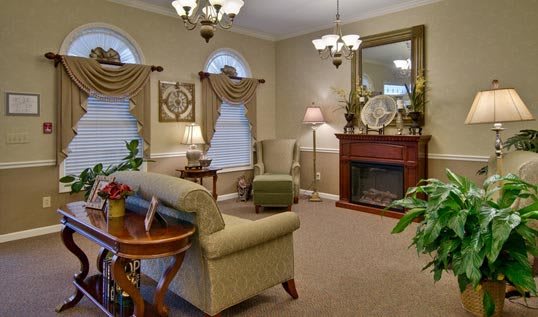 A traditional living room with elegant furnishings, including a fireplace and decorative accents.