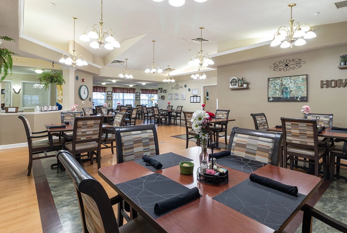A well-lit dining area with neatly arranged tables and chairs, featuring stylish decor.