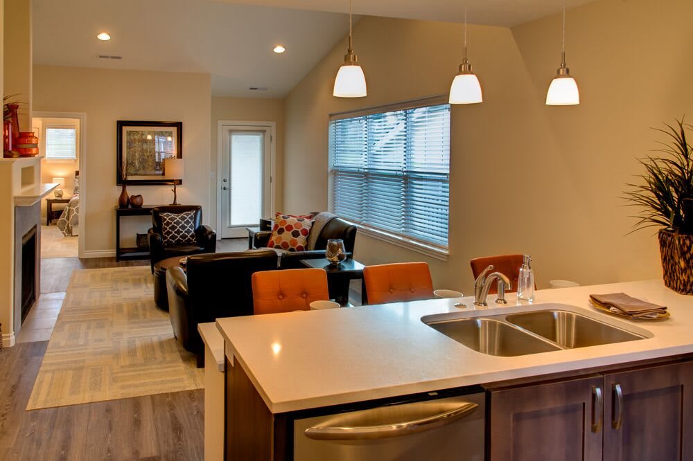 A modern open floor plan featuring a kitchen and living room with stylish furnishings and lighting.