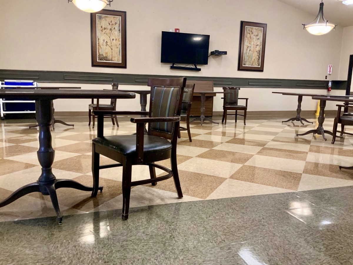A spacious room with chairs and tables, featuring a television and decorative wall art.