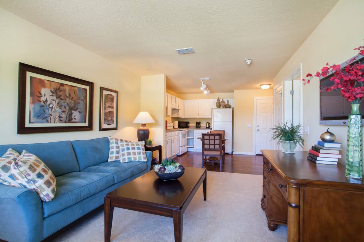 A cozy living and dining space featuring a comfortable sofa, coffee table, and an open kitchen area.