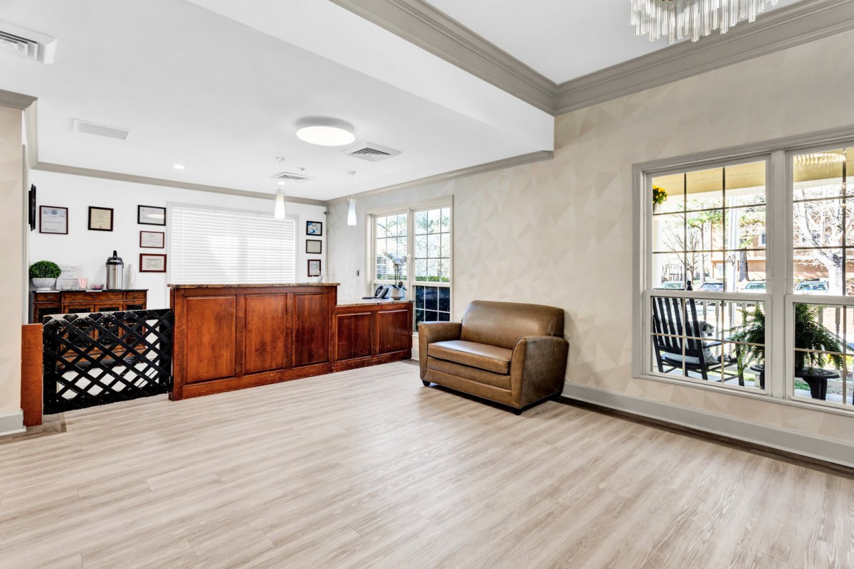 Modern reception area with a wooden desk and comfortable seating.
